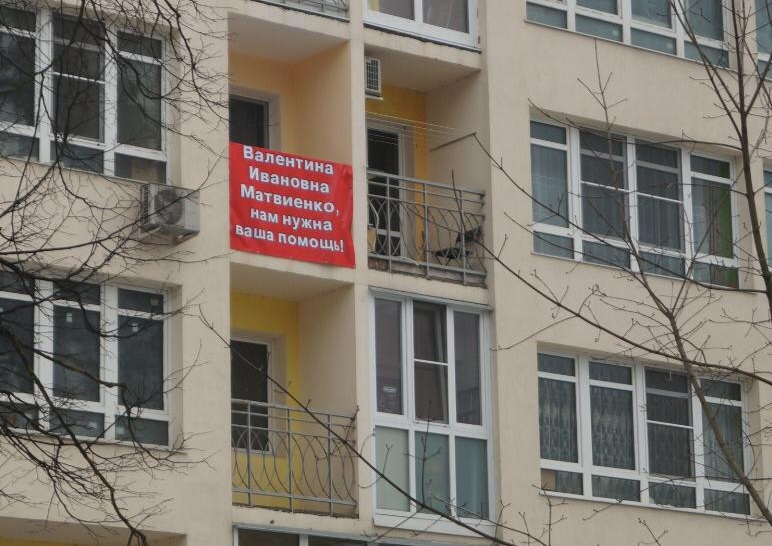 Жители дома вывесили плакаты с просьбой о помощи.